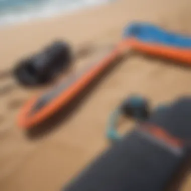 Close-up of kitesurfing equipment laid out on the sandy beach.