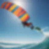 A vibrant kite soaring against a clear blue sky over an ocean