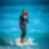 Wetsuit Fit and Surfing A tall woman in a well-fitted wetsuit standing on a surfboard